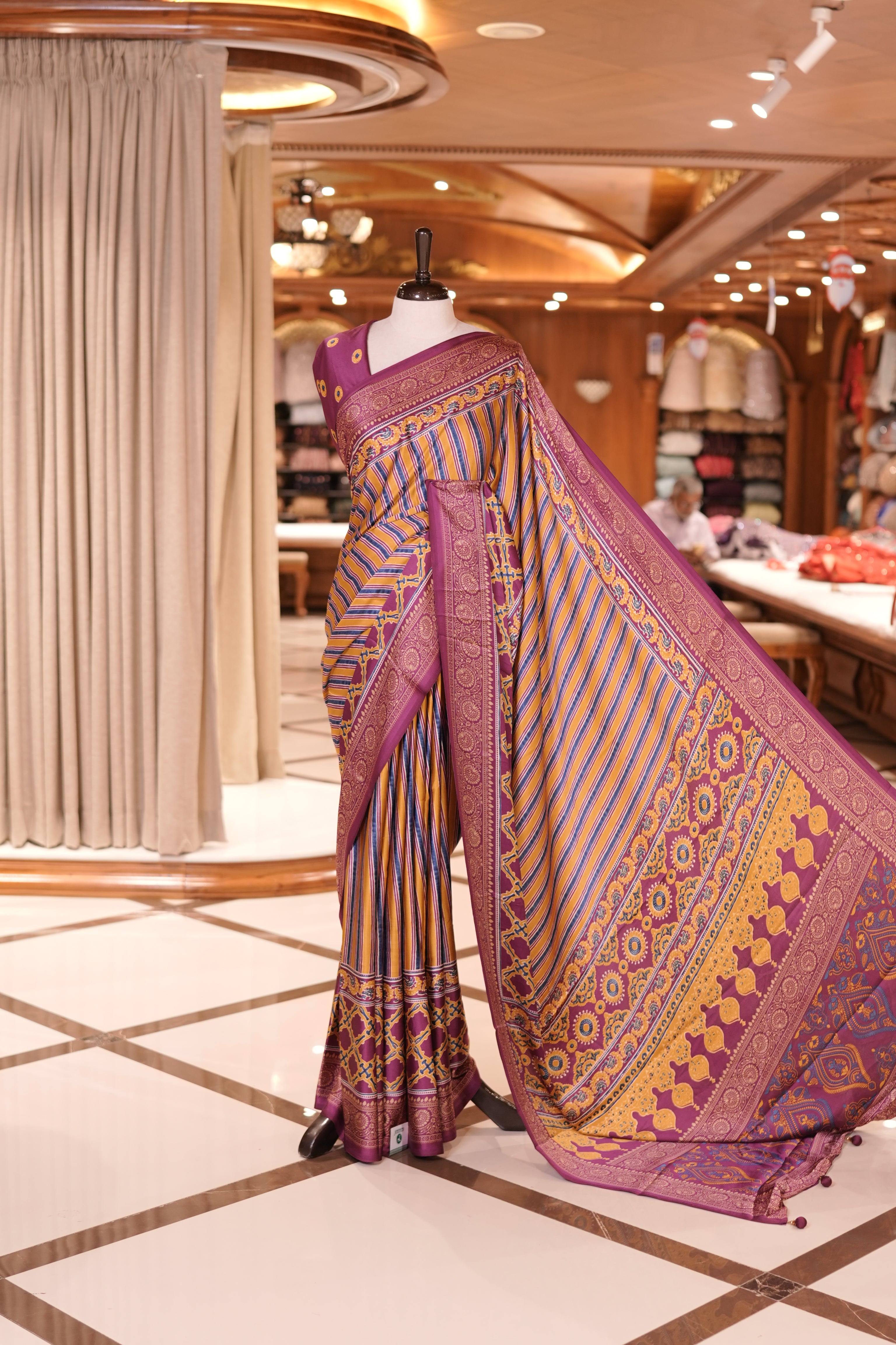 Magenta and multi colour semi modal saree featuring vibrant vertical stripes and intricate geometric motifs, beautifully highlighted with an ornate traditional border, and paired with a perfectly matching blouse.