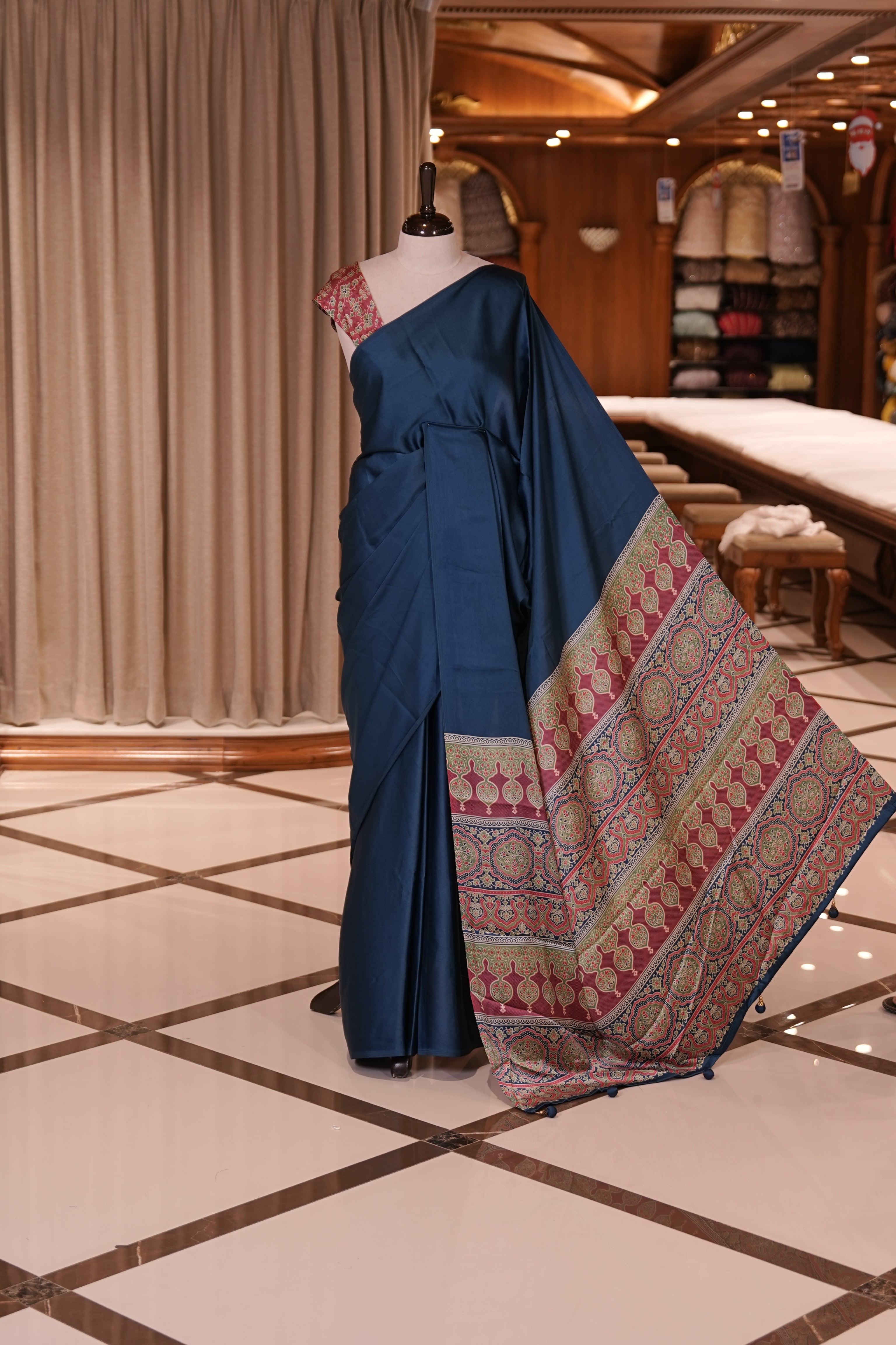 Blue Colour semi modal saree featuring a graceful solid body, beautifully enhanced with an intricately woven contrast Ajrakh printed pallu and a perfectly matching Ajrakh blouse.