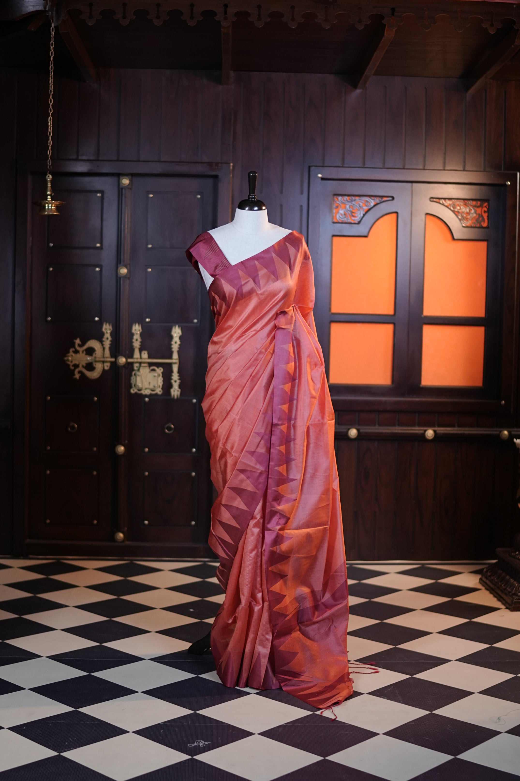 Orange colour Net cotta saree featuring a striped body with a contrast colored traditional temple-design border, a striped pallu, and paired with a matching blouse.