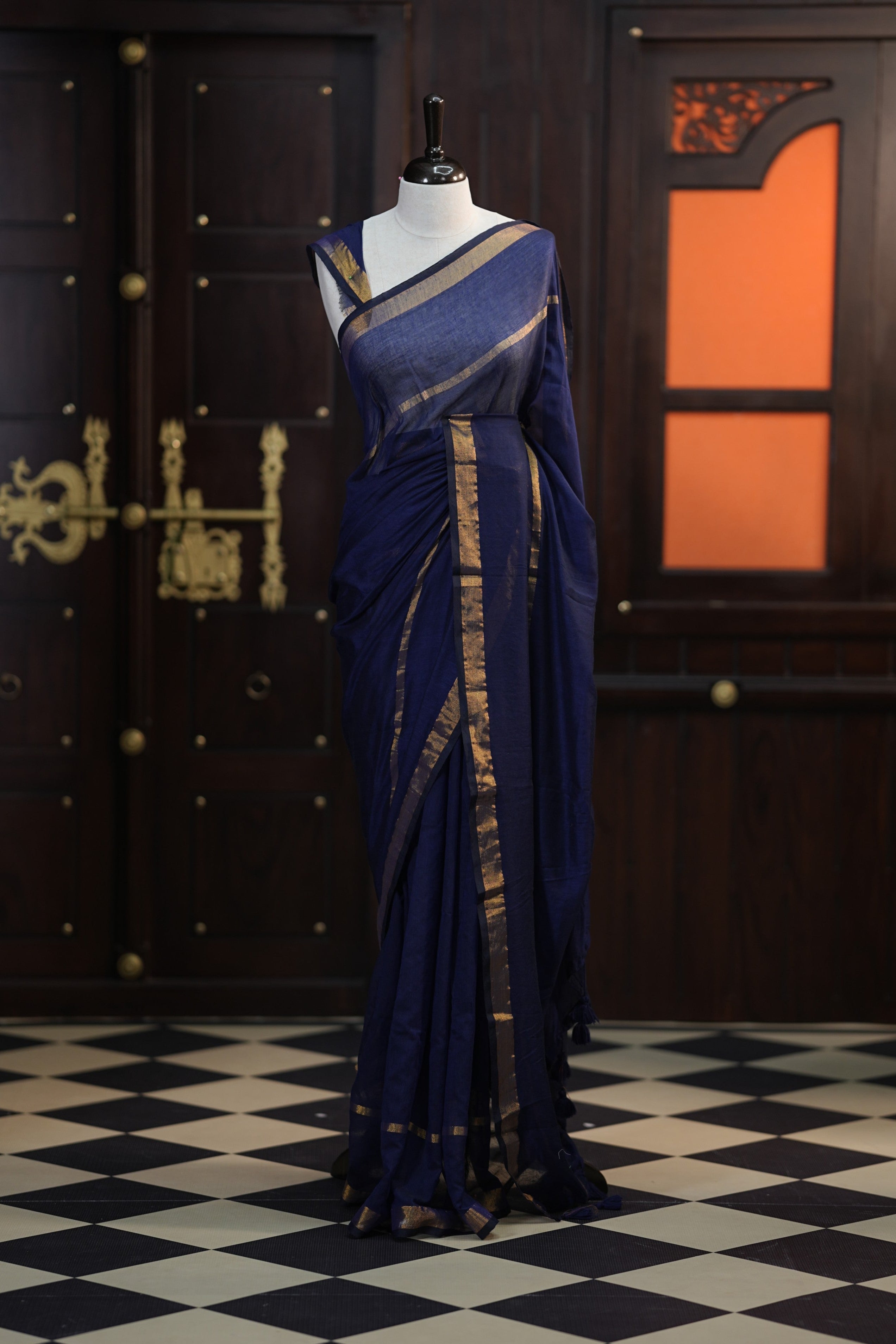 Navy blue colour mul mul cotton saree accentuated by delicate Gold borders and body, paired with a matching blouse.