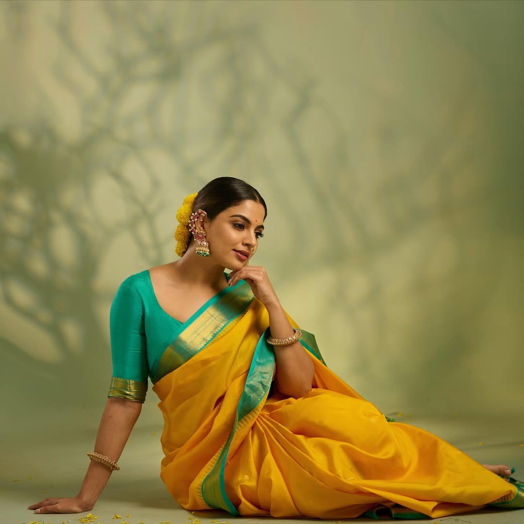 Sunshine yellow colour Kanchipuram Silk saree, featuring intricate gold motifs, a vibrant teal green border, and a grand pallu paired with a matching blouse