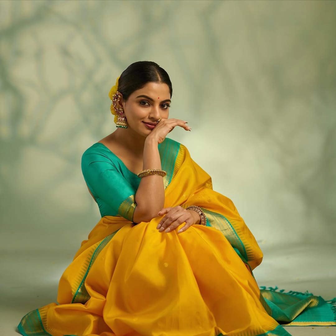 Sunshine yellow colour Kanchipuram Silk saree, featuring intricate gold motifs, a vibrant teal green border, and a grand pallu paired with a matching blouse