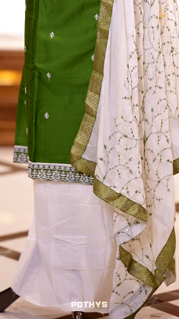 Green colour semi silk salwar set highlighted with intricate white chikankari embroidery on the neckline and body, paired with matching bottom and contrasting ivory dupatta.