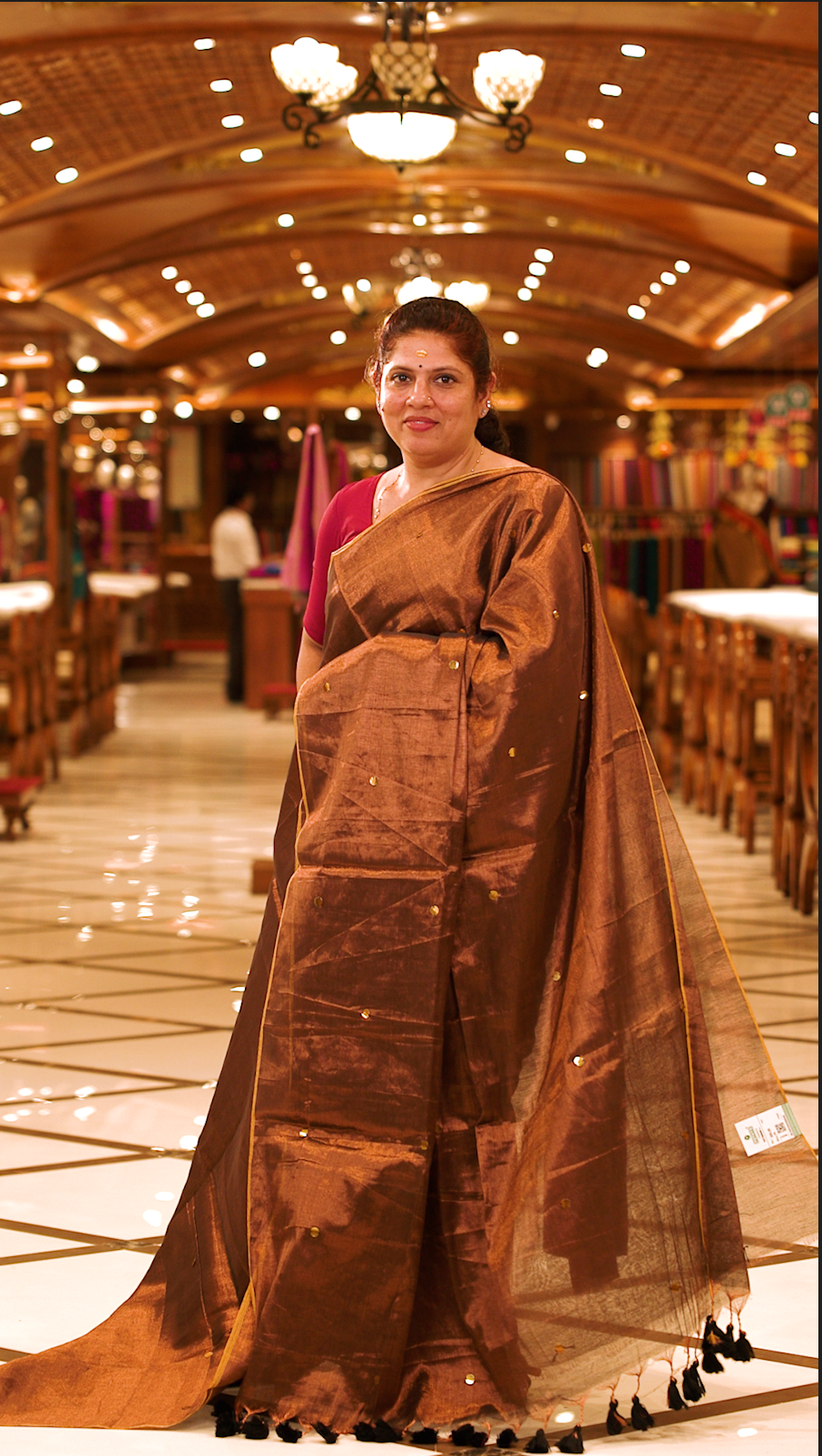 Brown colour Semi Tissue saree featuring a plain body adorned with delicate sequin detailing throughout, crafted in a borderless design. Comes without a blouse piece.