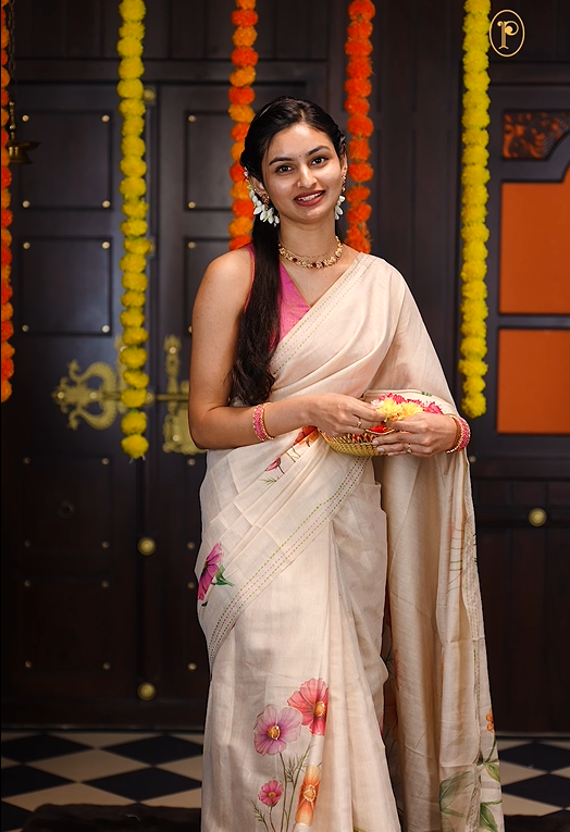 Cream colour soft tissue saree featuring Orange & pink floral print on body with gold zari outline, kantha stitched detailing border, same print & tassels on pallu, Small floral Print running blouse piece