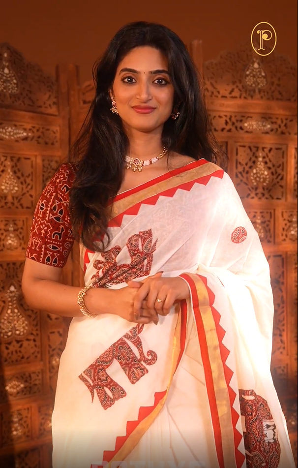 Cream colour Kerala saree Featuring Ajrakh Inspired Buttas Red Elephant pattern, Gold zari border, comes with matching blouse piece.