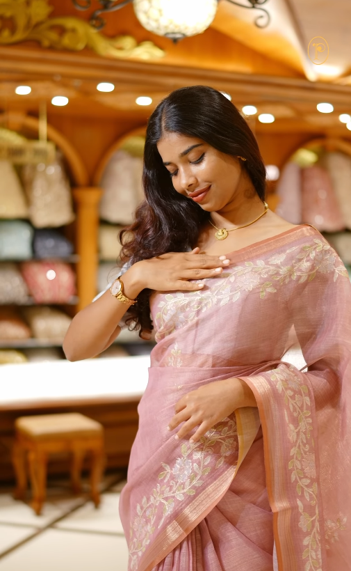 Onion pink colour linen tissue saree featuring Floral design with Aari work & contrast simple border, comes with matching blouse piece.