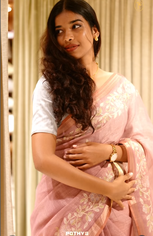Onion pink colour linen tissue saree featuring Floral design with Aari work & contrast simple border, comes with matching blouse piece.