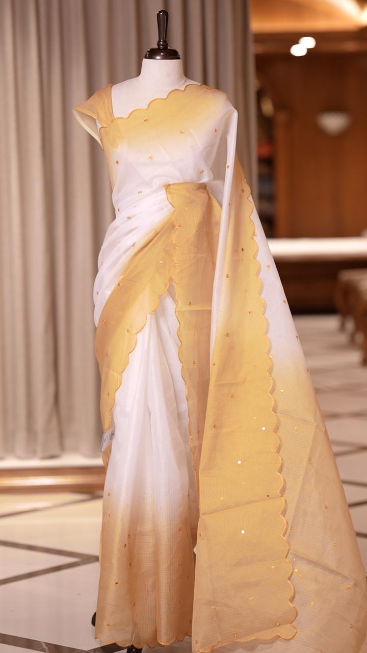 Yellow colour Doriya check cotton saree with soft sequins work on the body, elegant embroidery scallop border, and a simple pallu & Comes with a matching plain blouse piece.