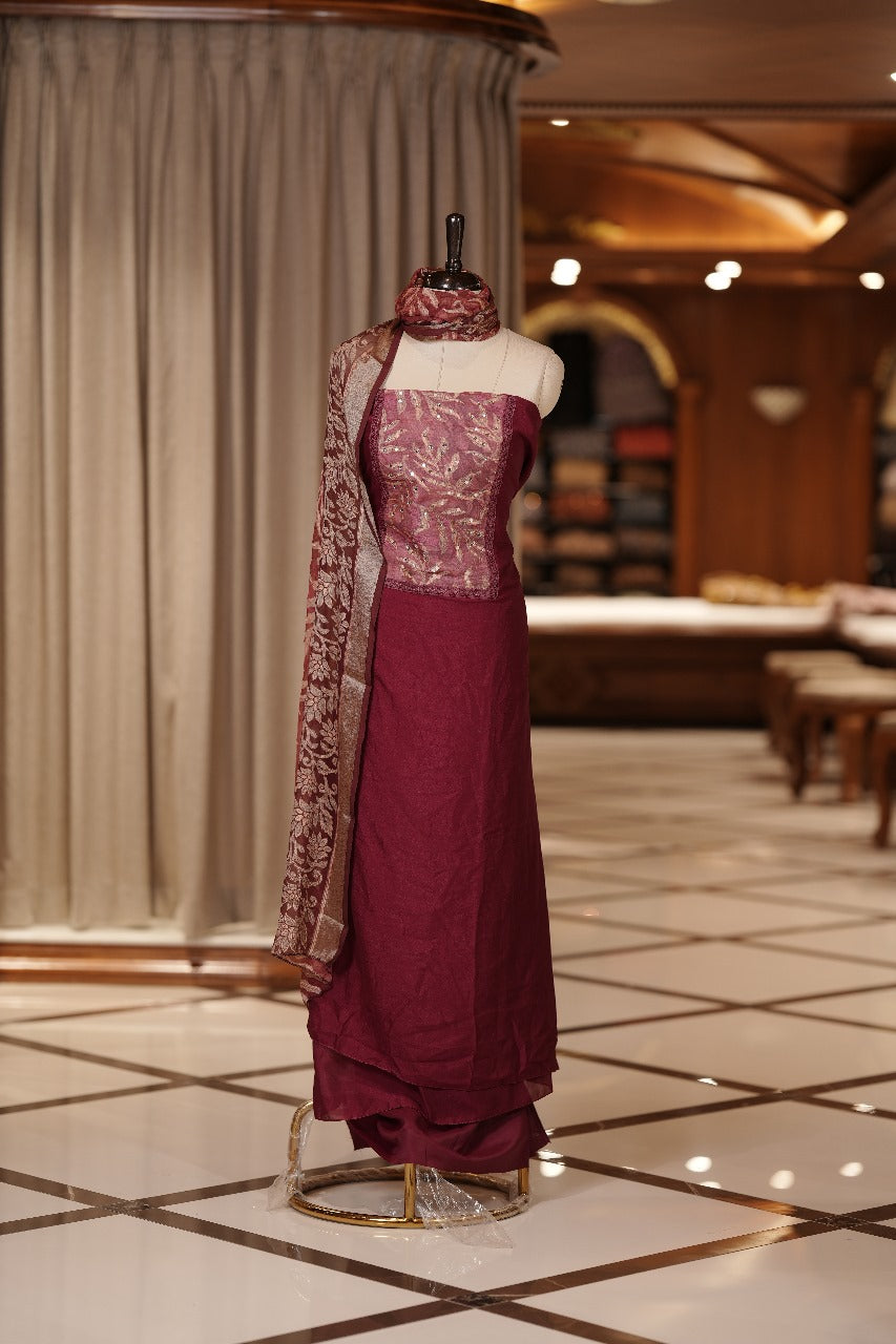 Maroon colour Vichithra silk Salwar suit featuring rich Leaf design & Mirror worked neckline, Chiffon printed dupatta & paired with a plain bottom.