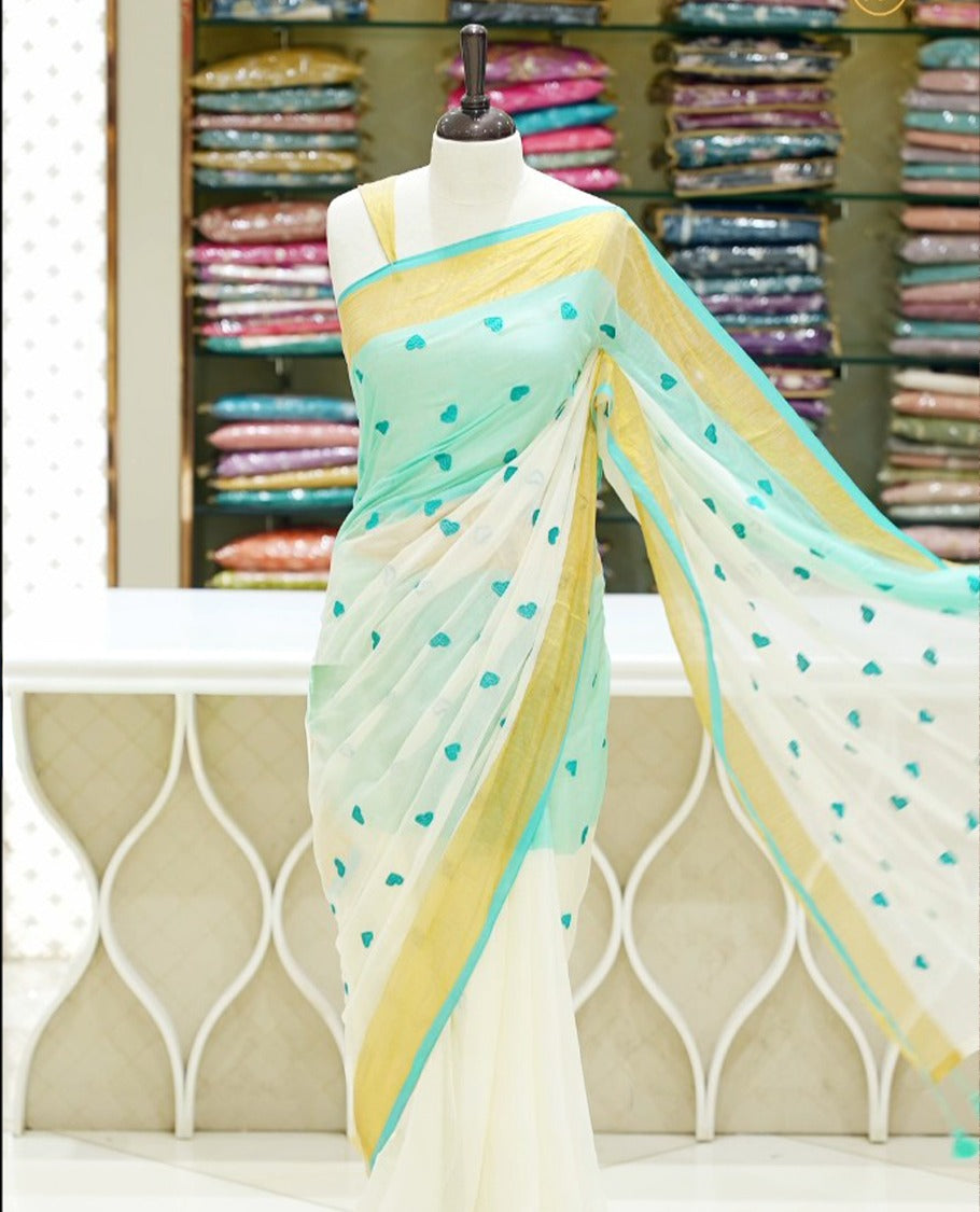 Blue and off-white mul cotton saree featuring a thread heart designed body, complemented by a Kasavu border, without a blouse piece.