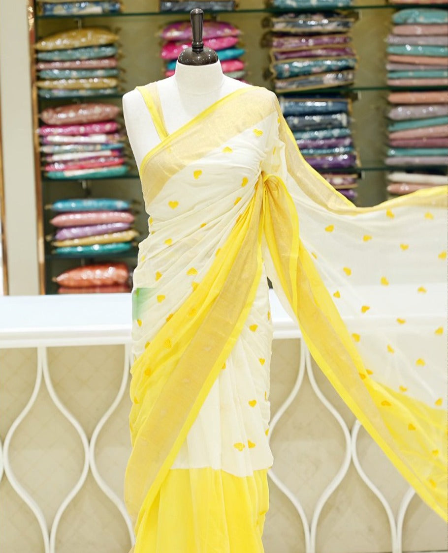 Yellow and off-white mul cotton saree featuring a thread heart designed body, complemented by a Kasavu border, without a blouse piece.