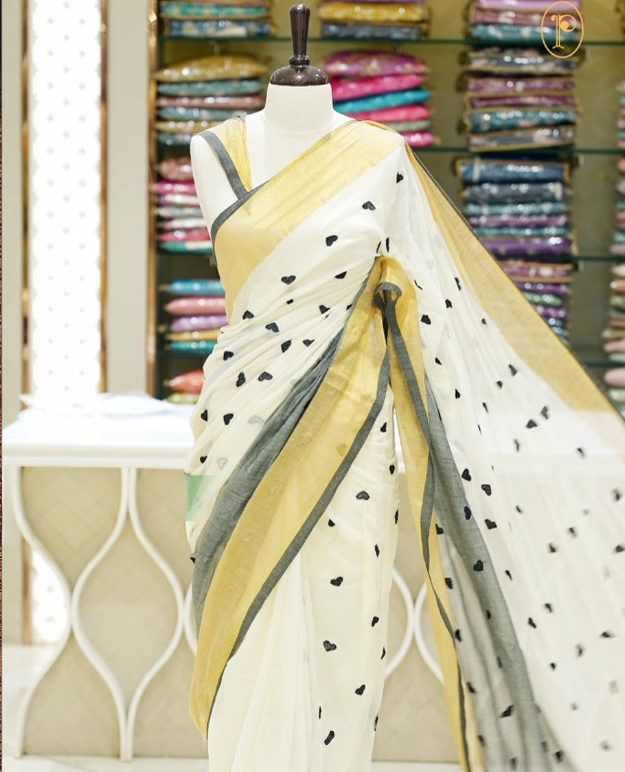 Black and off-white mul cotton saree featuring a thread heart designed body, complemented by a Kasavu border, without a blouse piece.