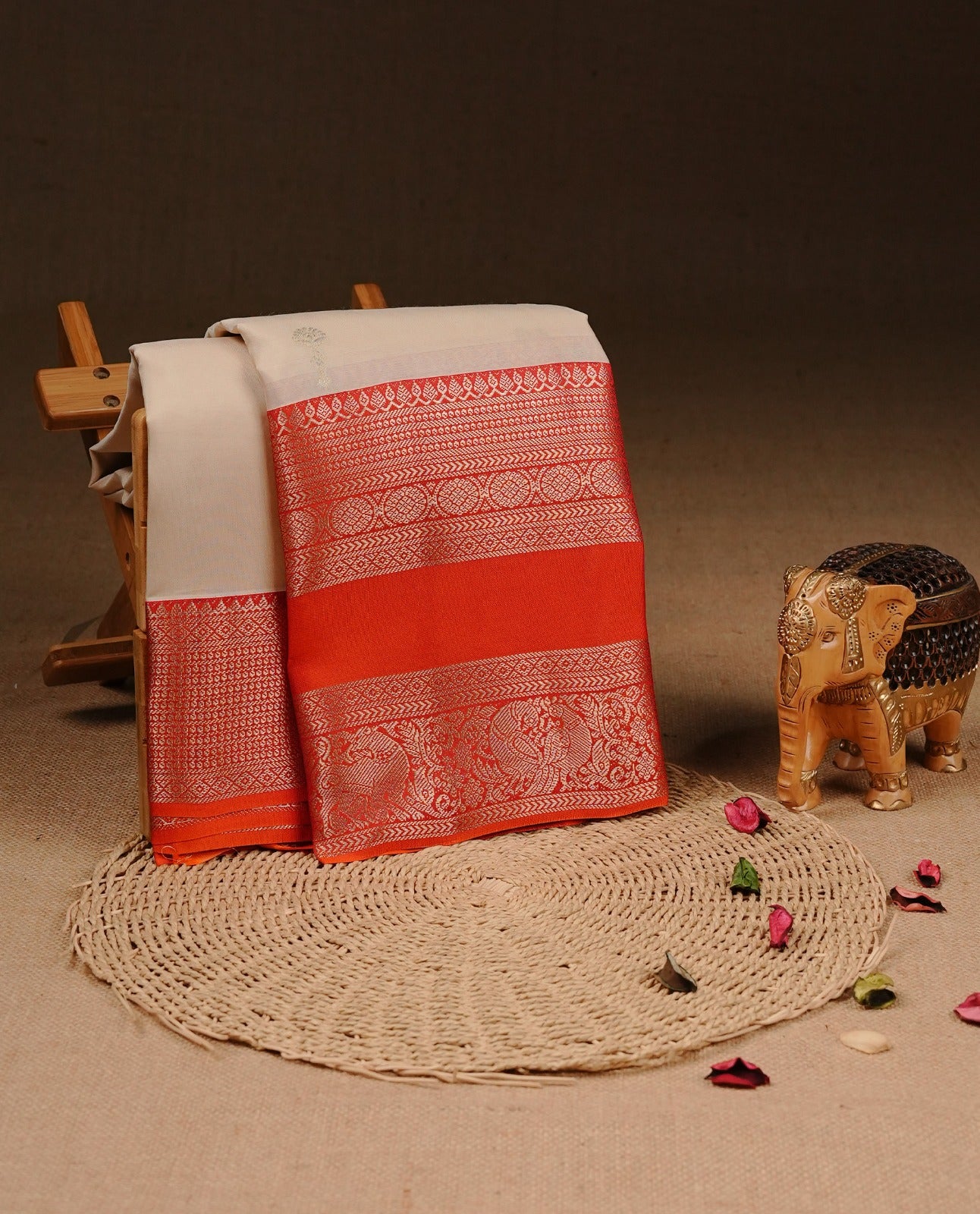 Cream colour Traditional Kancheepuram silk saree featuring gold zari motifs on body, enhanced with contrast Orange with traditional border, paired with matching blouse piece.