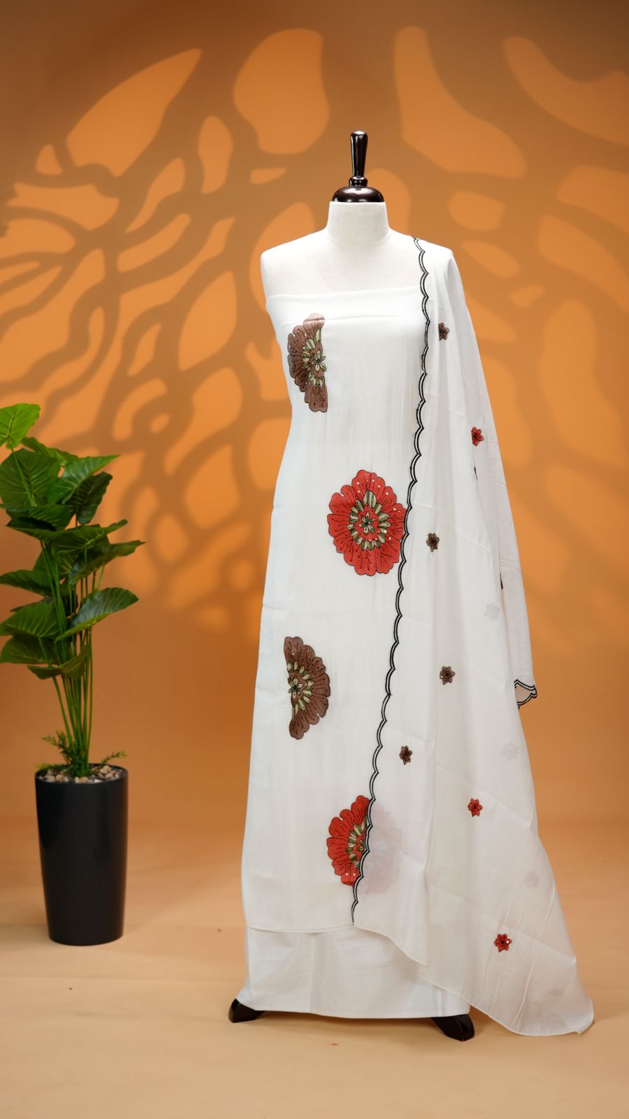 White Colour Mul Chanderi Salwar Material Featuring Olive Green Colour Floral Thread Work on body, paired with matching santoon Material Bottom & Floral thread Worked motifs And Scallop Embroidery Black Border Dupatta.