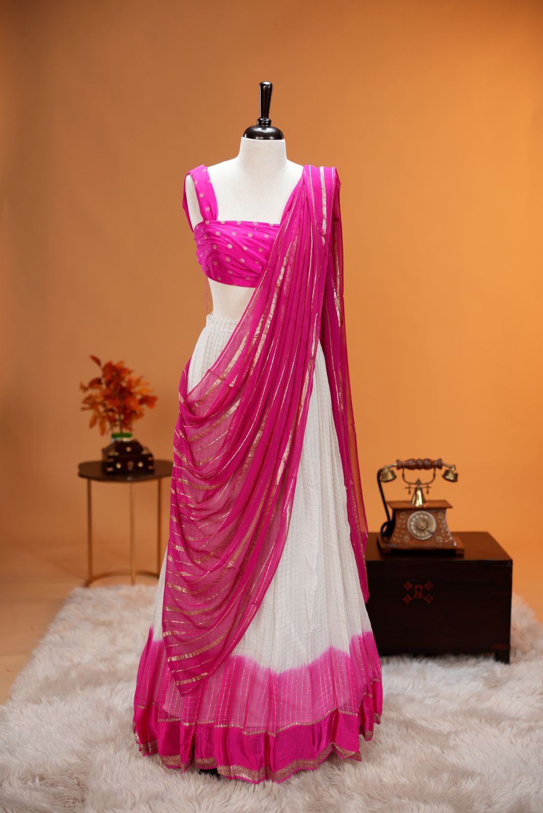 Pink colour Georgette Dhavani material featuring white skirt with Check pattern & contrast border, Small floral work on blouse piece, same colour dupatta with strips.