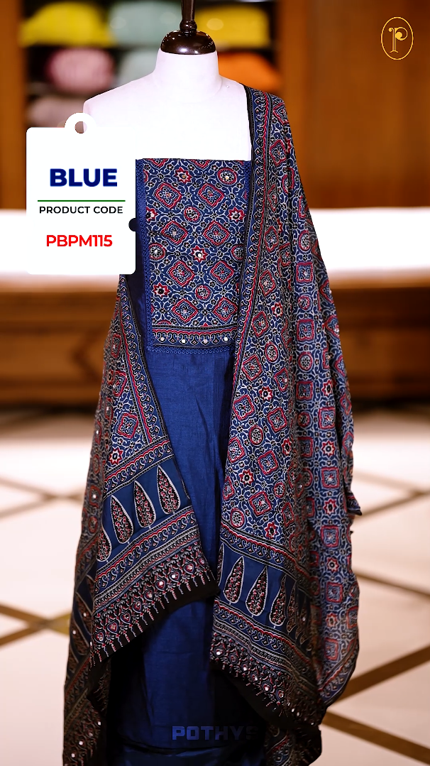 Blue colour Ajrakh print semi silk churidhar material with intricately patterned top, mirror work highlights, printed dupatta with detailed border, and plain bottom perfect for elegant festive and casual wear.
