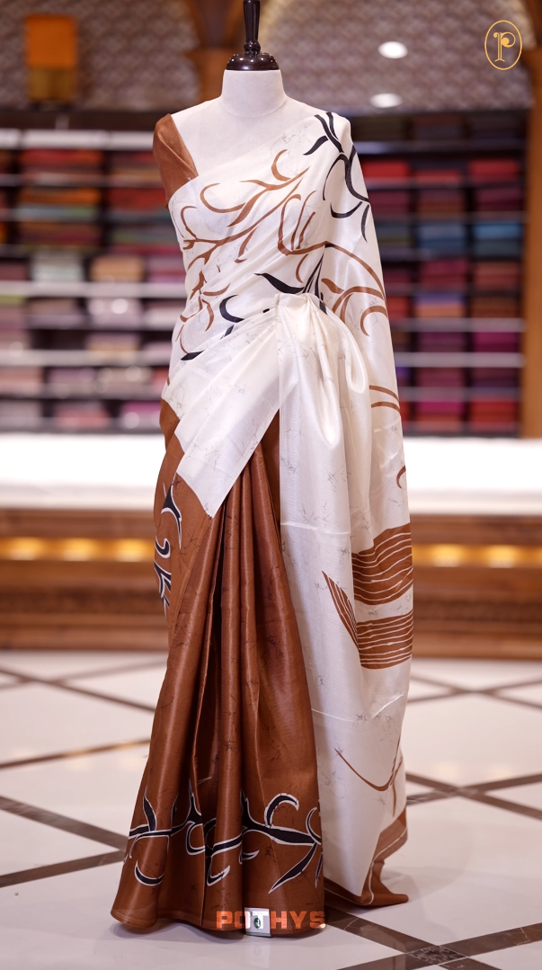 Dusty mustard colour saree adorned with bold off white floral prints, blending tradition with a modern twist & paired with a matching blouse.