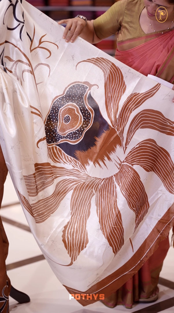 Dusty mustard colour saree adorned with bold off white floral prints, blending tradition with a modern twist & paired with a matching blouse.