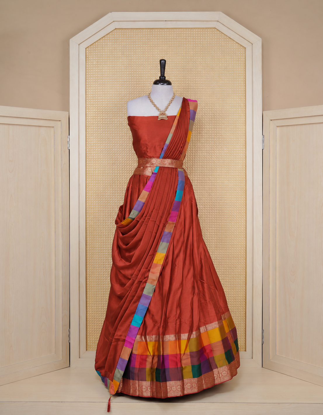 Brick Red colour Semi Silk Semi stitched dhavani set featuring a Plain body with a matching Multi colour with gold zari bordered skirt & blouse piece and dupatta.