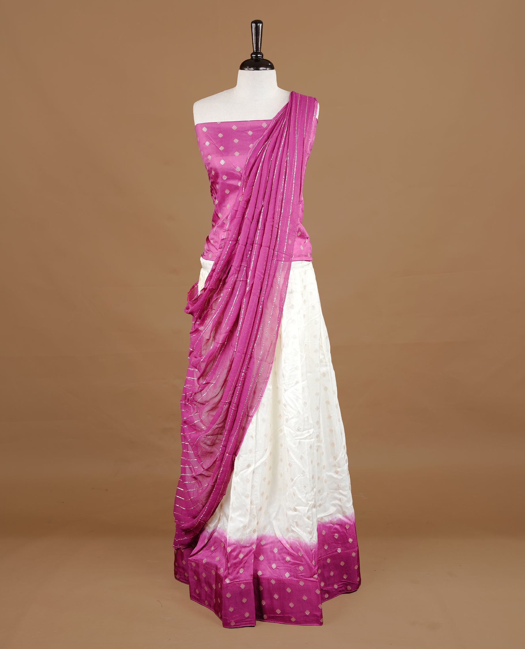 Off White colour semi stitched half saree material featuring delicate zari buttas on the blouse and skirt, paired with a contrast pink zari border and matching striped dupatta