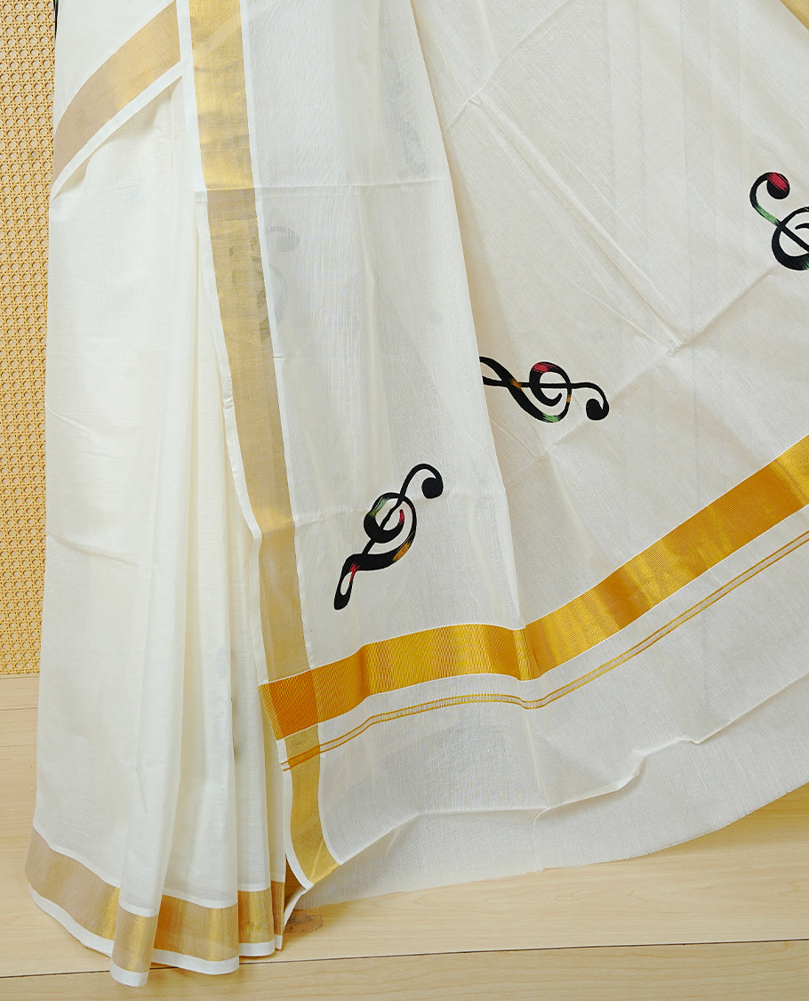 Cream Colour Kerala Saree Featuring Black Instrument Motifs And A Classic Gold Zari Border, Paired With A Matching Blouse Piece.