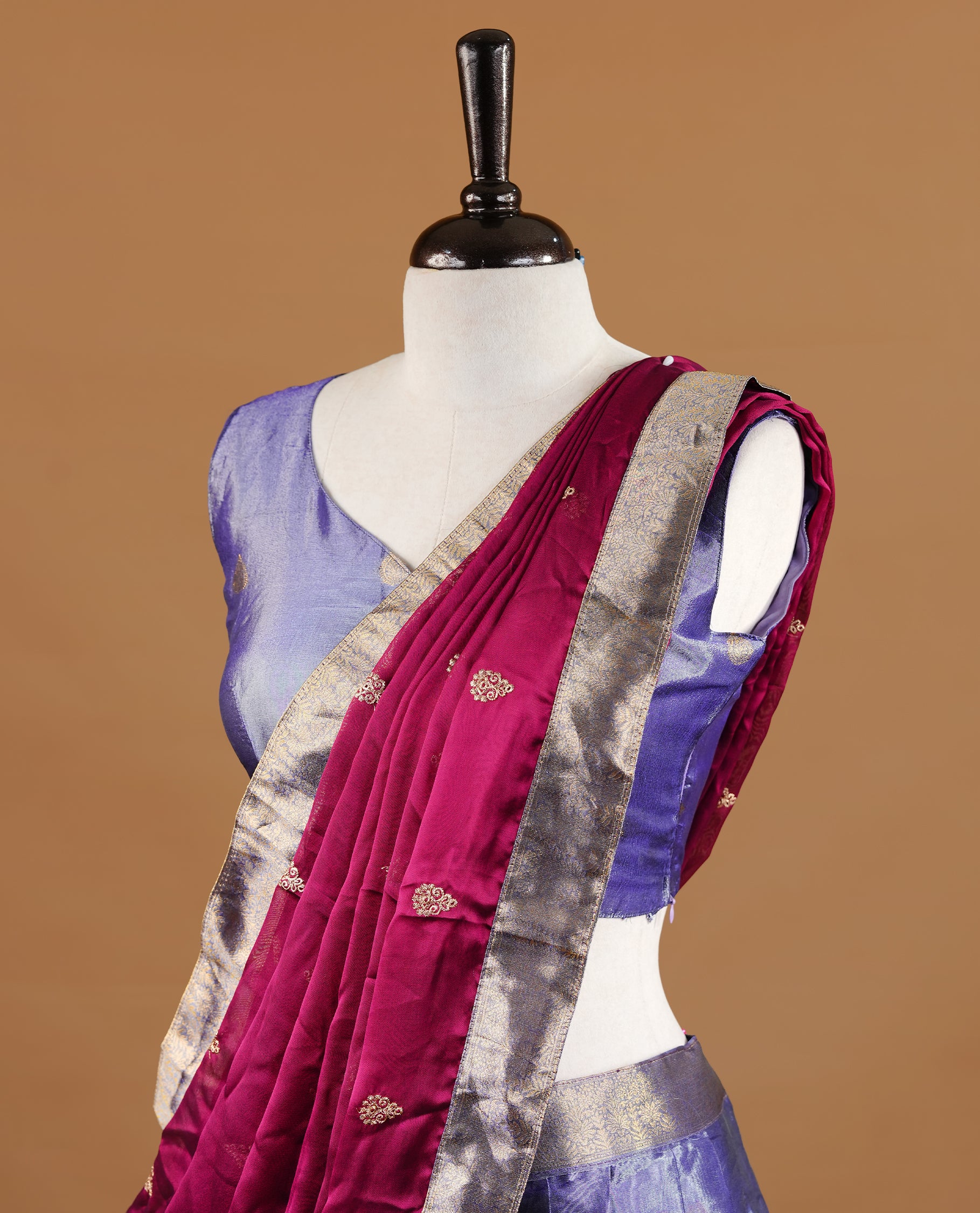 Lavender colour featuring lavender colour skirt highlighting gold zari motifs & border, contrast maroon dupatta, with matching stitched blouse.
