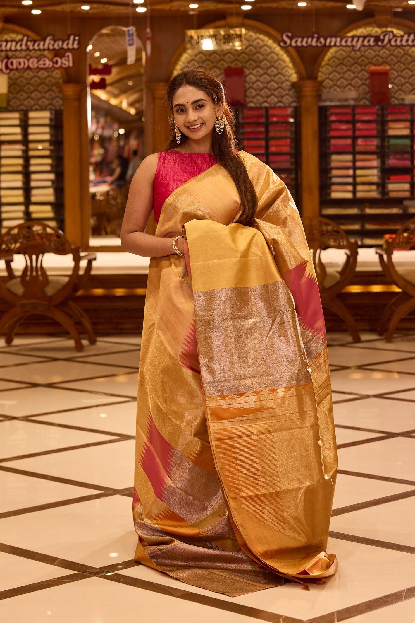 Elegant golden beige colour Kancheepuram silk saree featuring subtle woven geometric highlights with soft pink accents, beautifully paired with a rich contrast pallu and styled with a vibrant blouse