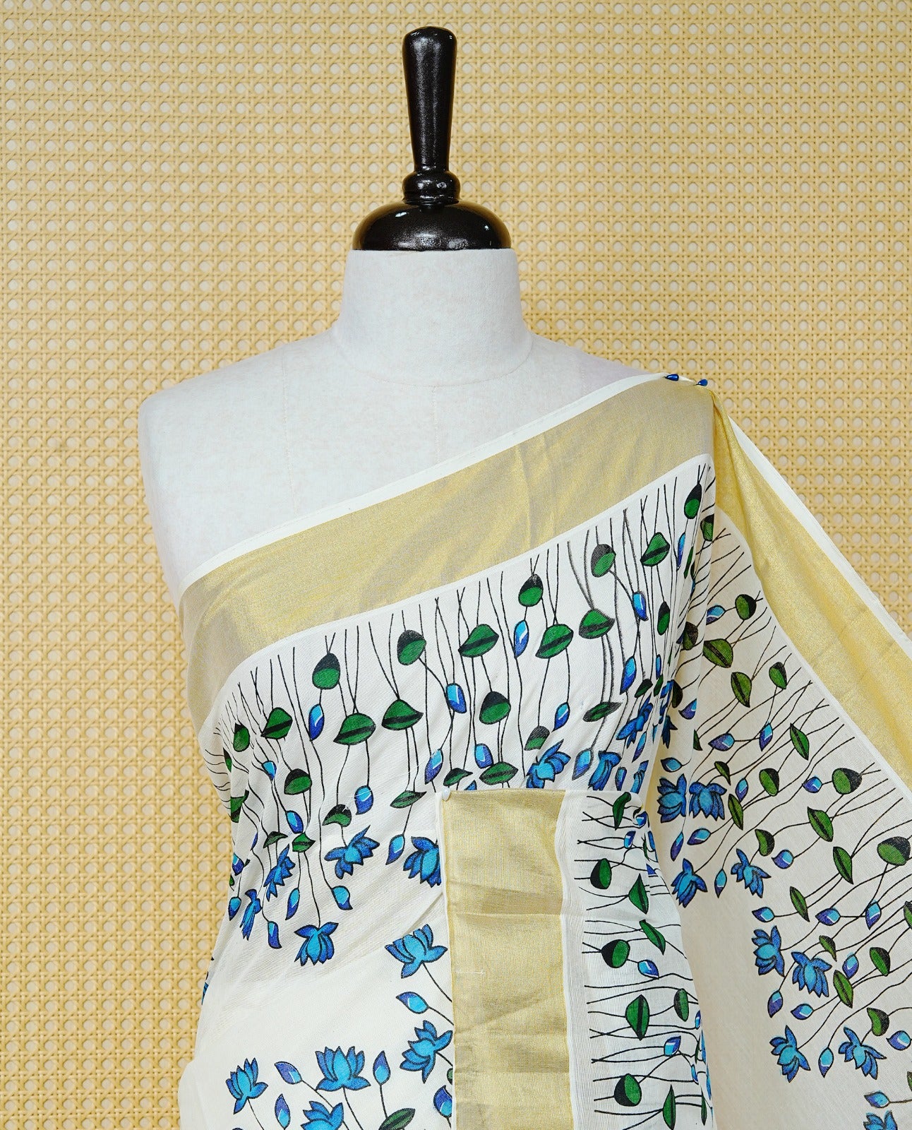 Cream Colour Cotton Kerala Saree Featuring Delicate Blue Floral Print Across The Body, Enhanced With A Gold Zari Border And A Rich Gold Zari Pallu, Finished With A Matching Blouse Piece
