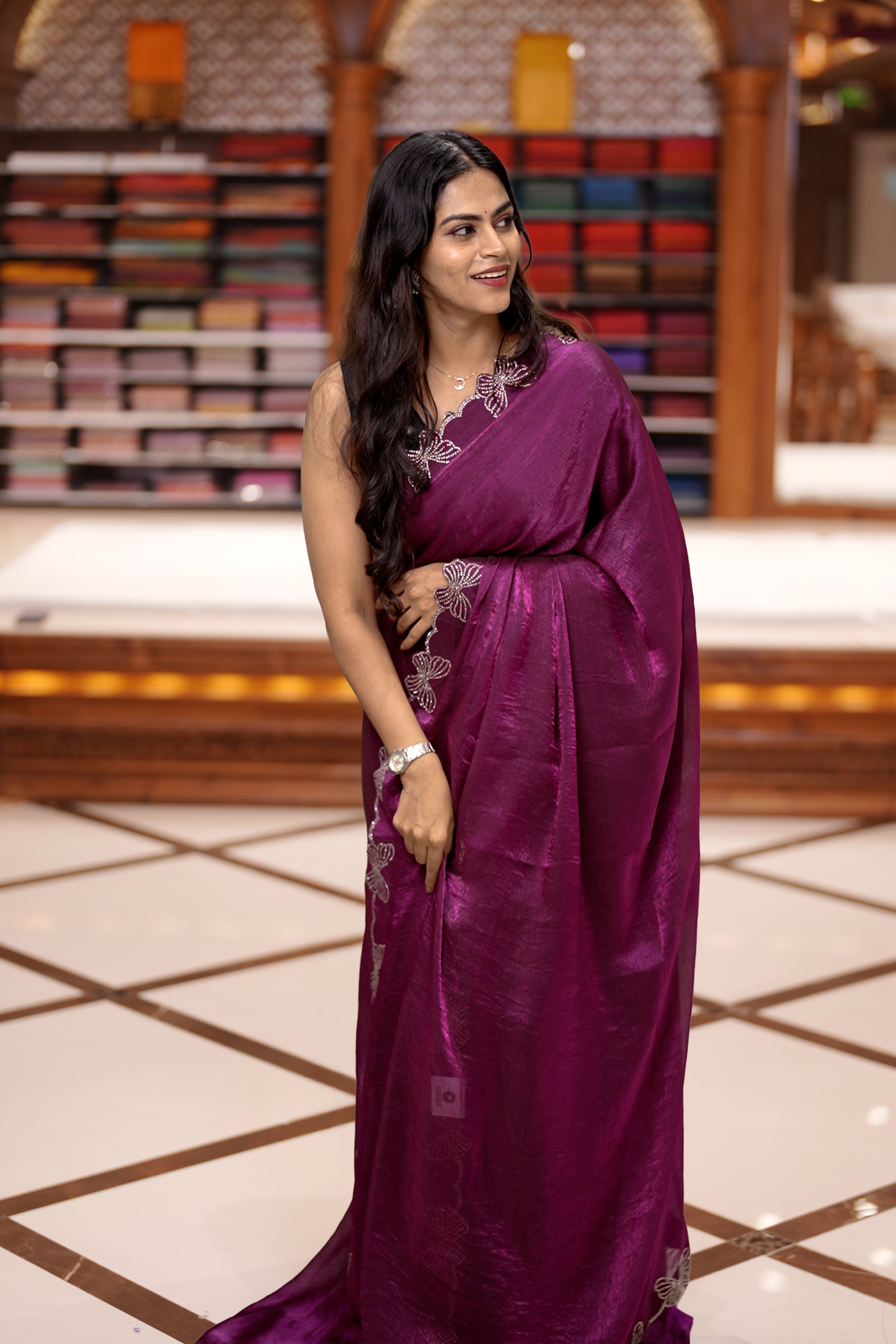 Purple colour chiffon saree adorned with Swarovski stone butterfly designs along the side border, adding a touch of sparkle, Paired with a matching blouse piece featuring the same intricate stone work.