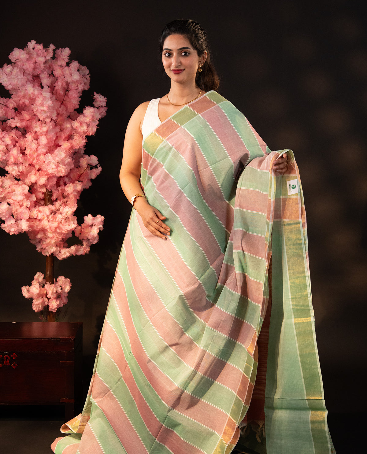 Green & Wine dual colour Poly cotton saree featuring Stripped design body, complemented by kasavu border and pallu Finished with elegant tassels, comes with matching blouse piece.