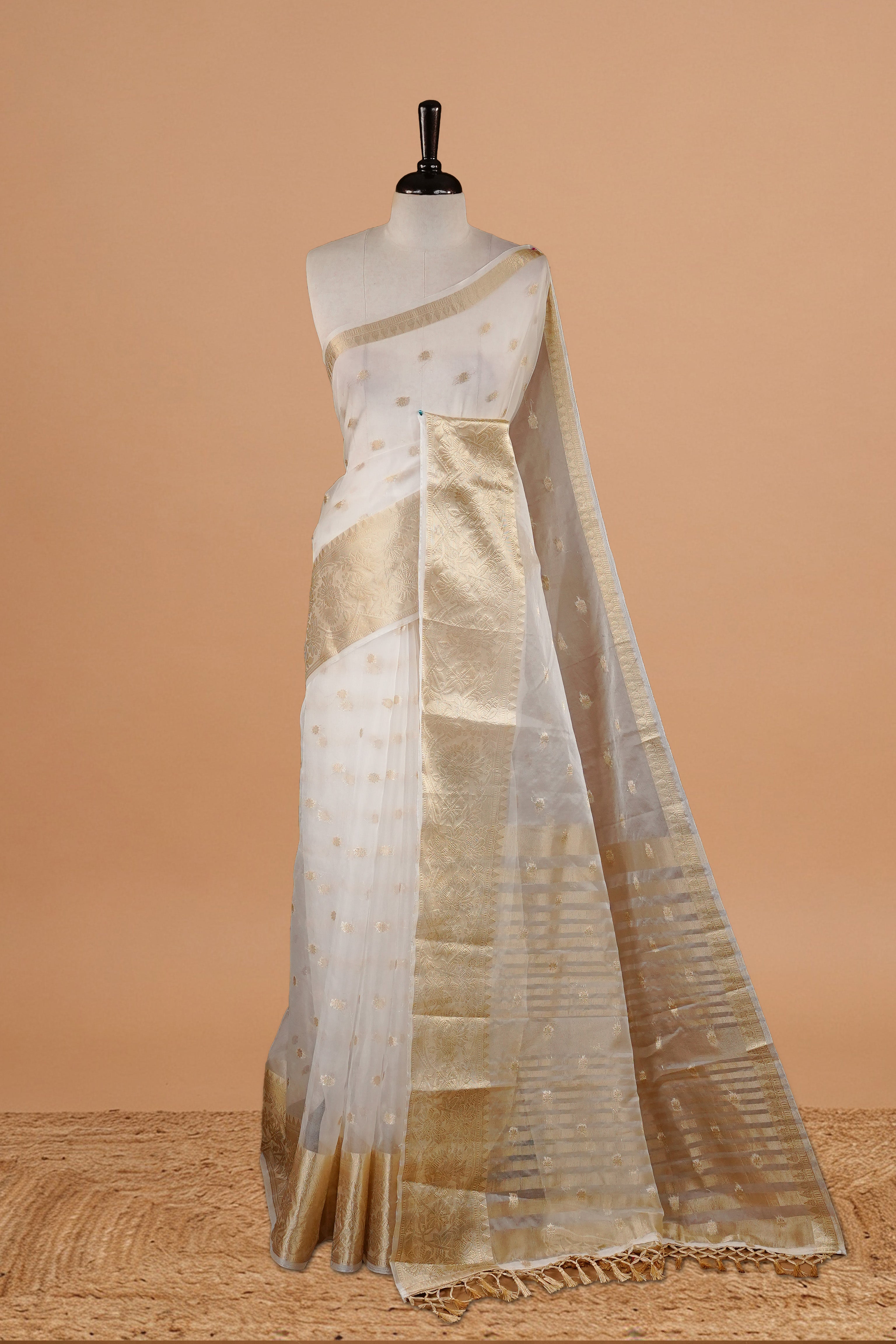 White Colour Semi Organza Saree Featuring Elegant Gold zari Floral motifs Detailing on body, Traditional border, comes with matching blouse piece.