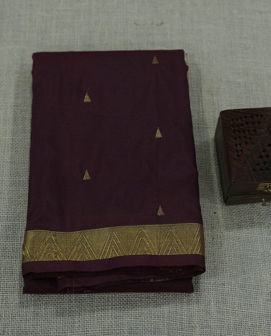 Maroon colour semi silk saree featuring subtle gold motifs and a finely woven zari border