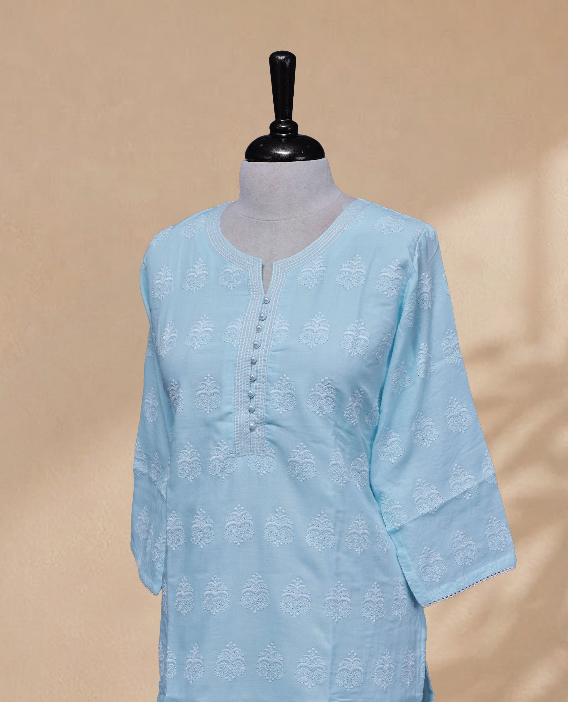 Blue Colour kurti featuring a classic U-shaped Thread Pattern neckline, Beads & Light Blue Floral Prints on the body, and sleeves.