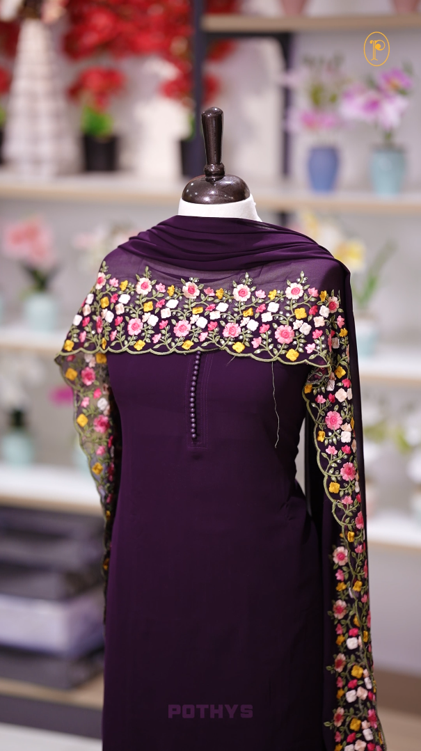 Wine colour Chiffon churidhar material featuring a plain top adorned with delicate beads work on the neckline, paired with a plain bottom, Highlighted by a dupatta with floral embroidery, sequins, and scalloped edges.