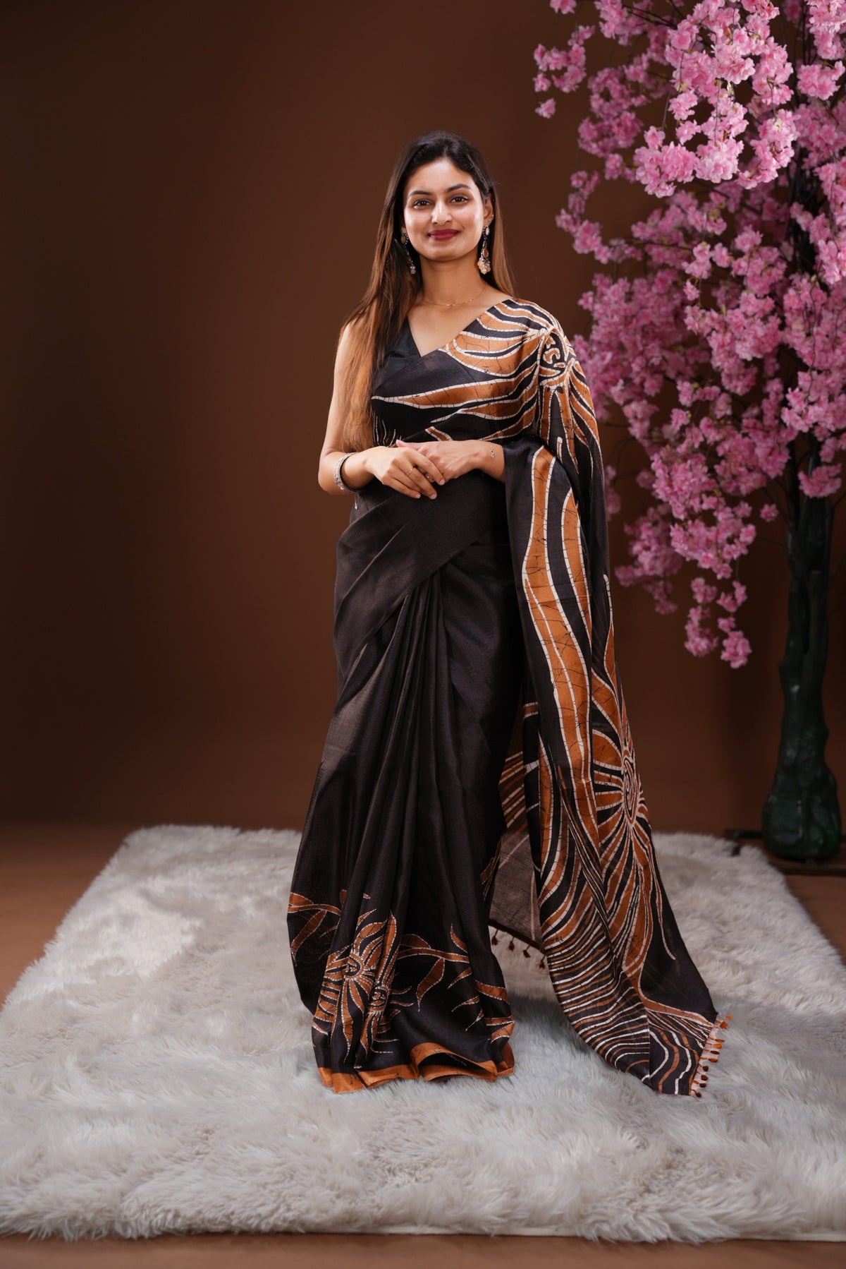 Black colour Semi Khadi Silk Saree featuring a plain black body, complemented by a rust orange colour geometric pattern on border and paired with a matching blouse piece.