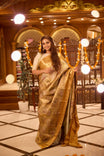 Gold colour Kancheepuram handloom tissue saree with Meena floral design, gold zari border and pallu, paired with matching blouse piece.