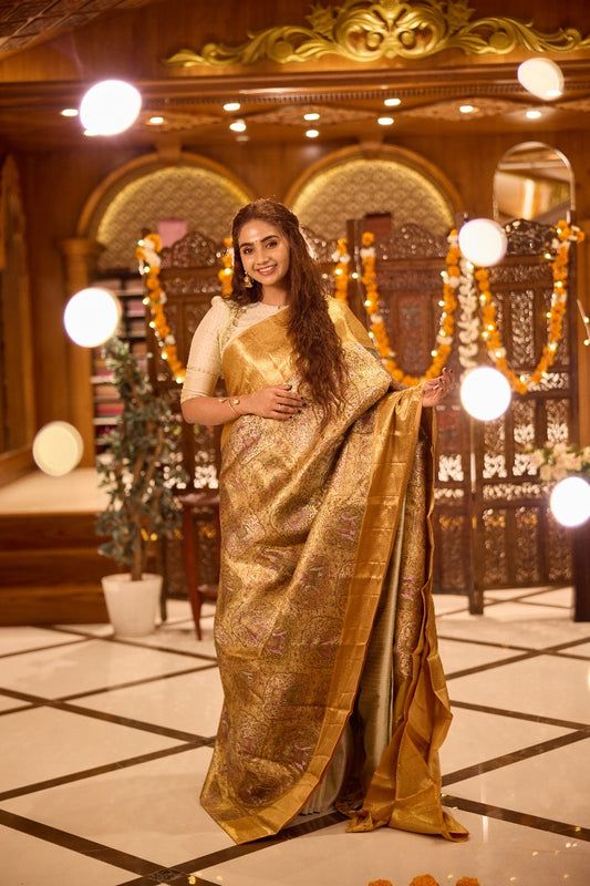Gold colour Kancheepuram handloom tissue saree with Meena floral design, gold zari border and pallu, paired with matching blouse piece.
