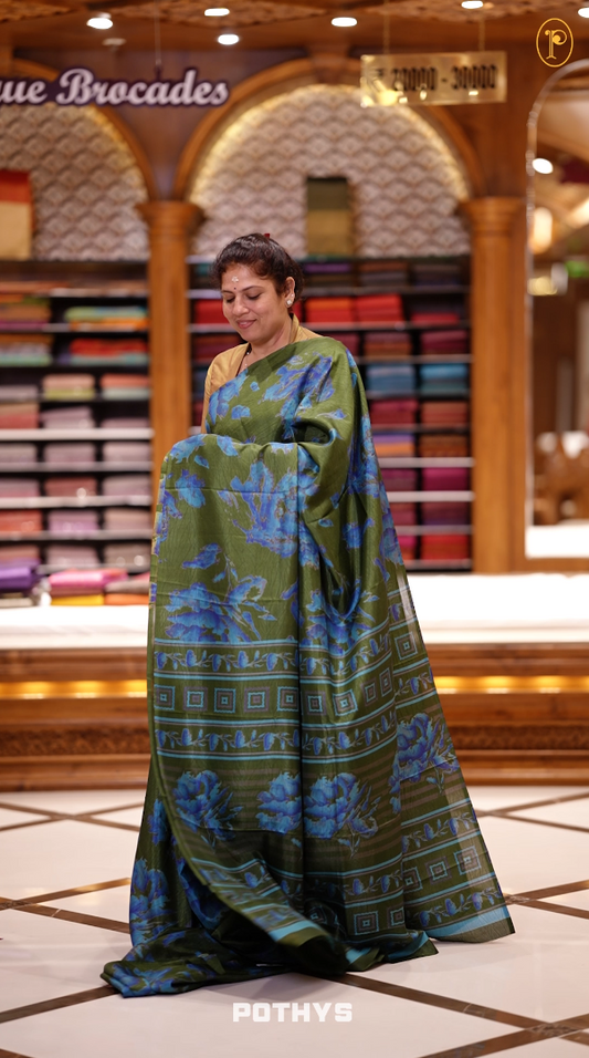 Green & Blue colour semi silk saree enhanced with a vibrant blue colour floral prints on body & pallu, and comes with a self printed blouse.