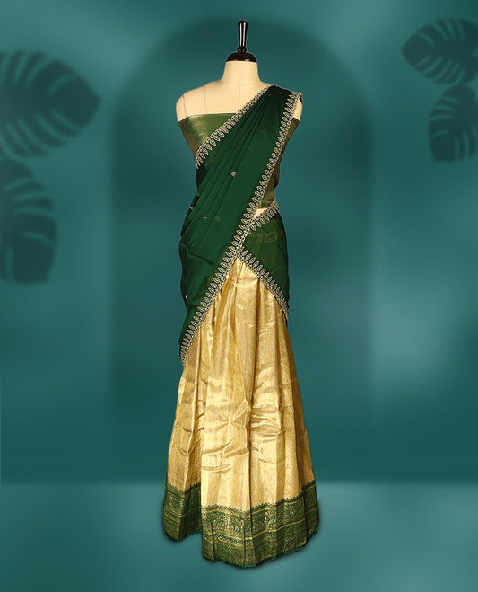 Elegant Semi stitiched green and gold Dhavani set featuring a lustrous gold skirt with intricate zari weave and matching green border, paired with a deep green dupatta embellished with delicate zari motifs for a regal look