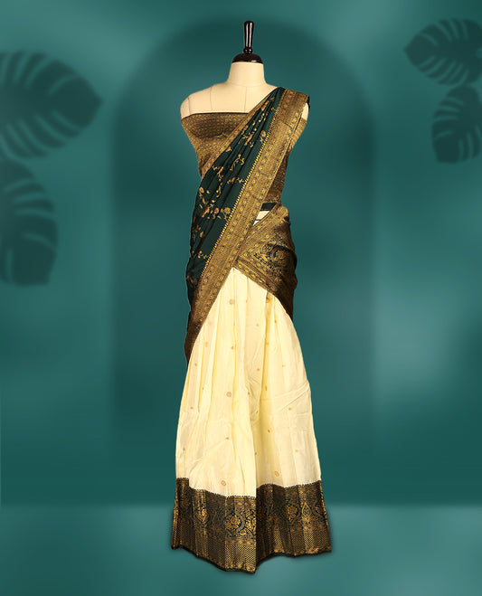 Graceful Semi stitched cream and bottle green Dhavani set featuring a cream skirt with golden buttas and rich zari border, paired with a matching blouse and zari woven dupatta, perfect for weddings and festive occasions.