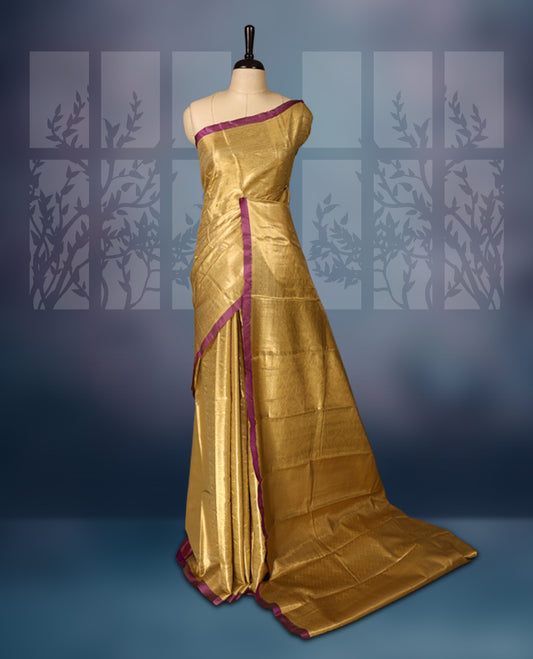 Golden semi silk brocade saree with intricate self brocade work across the body, paired with a rich contrast violet border and matching pallu. Includes a coordinating blouse for an elegant traditional look.