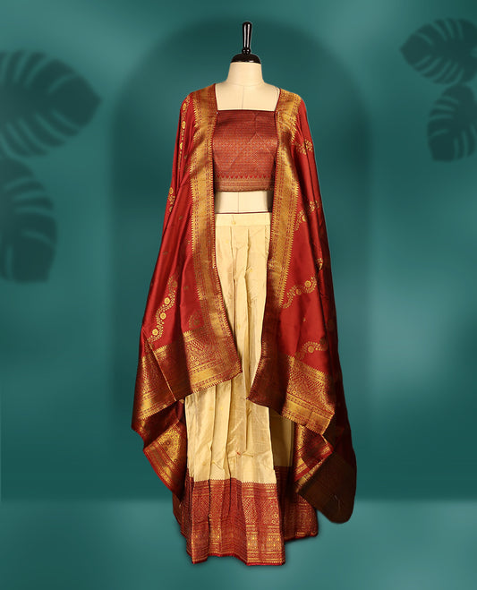 Traditional semi stitched dhavani in cream and rich maroon silk, highlighted with intricate zari motifs and border & A timeless piece ideal for weddings, festivals, and cultural celebrations.