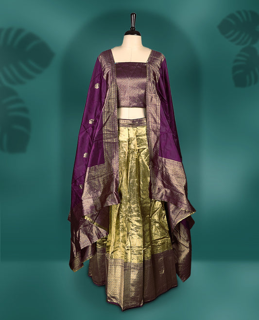 Rich Semi stitched purple and gold dhavani set featuring a zari detailed blouse, flowing dhavani, and golden pleated skirt, A perfect blend of tradition and elegance, ideal for festive occasions and cultural celebrations.