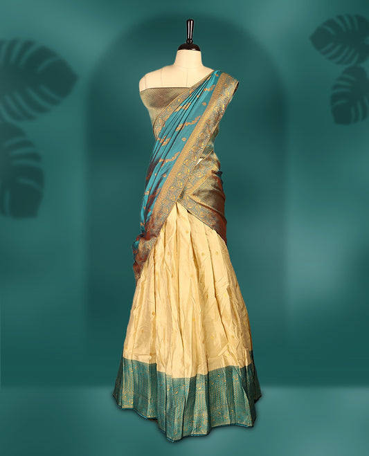 Chic semi stitched dhavani in cream and teal silk with delicate zari motifs and a rich pallu &  A perfect choice for traditional celebrations, blending elegance with customizable comfort and grace.