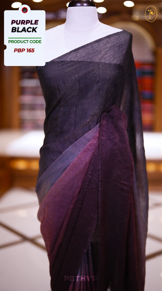 Purple black colour saree with a soft textured body in deep black, a rich pallu blending purple hues, and a subtle, seamless border for a graceful and contemporary drape & Comes with a matching blouse.
