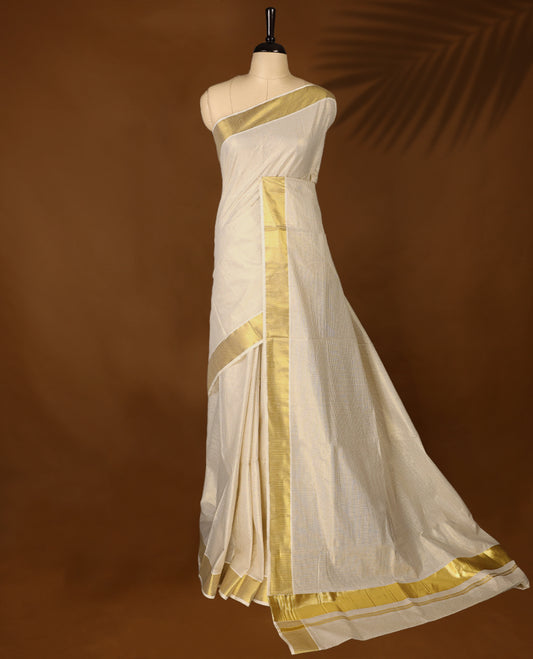 Elegant off white colour cotton Kerala saree featuring Tiny Checked body, gold zari traditional kasavu border offering a classic and graceful look, paired with a matching blouse.