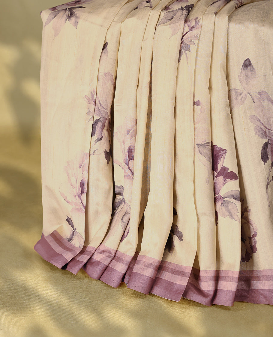 Cream colour semi silk printed saree adorned with printed floral motifs across the body, finished with a onion colour striped border, with matching blouse