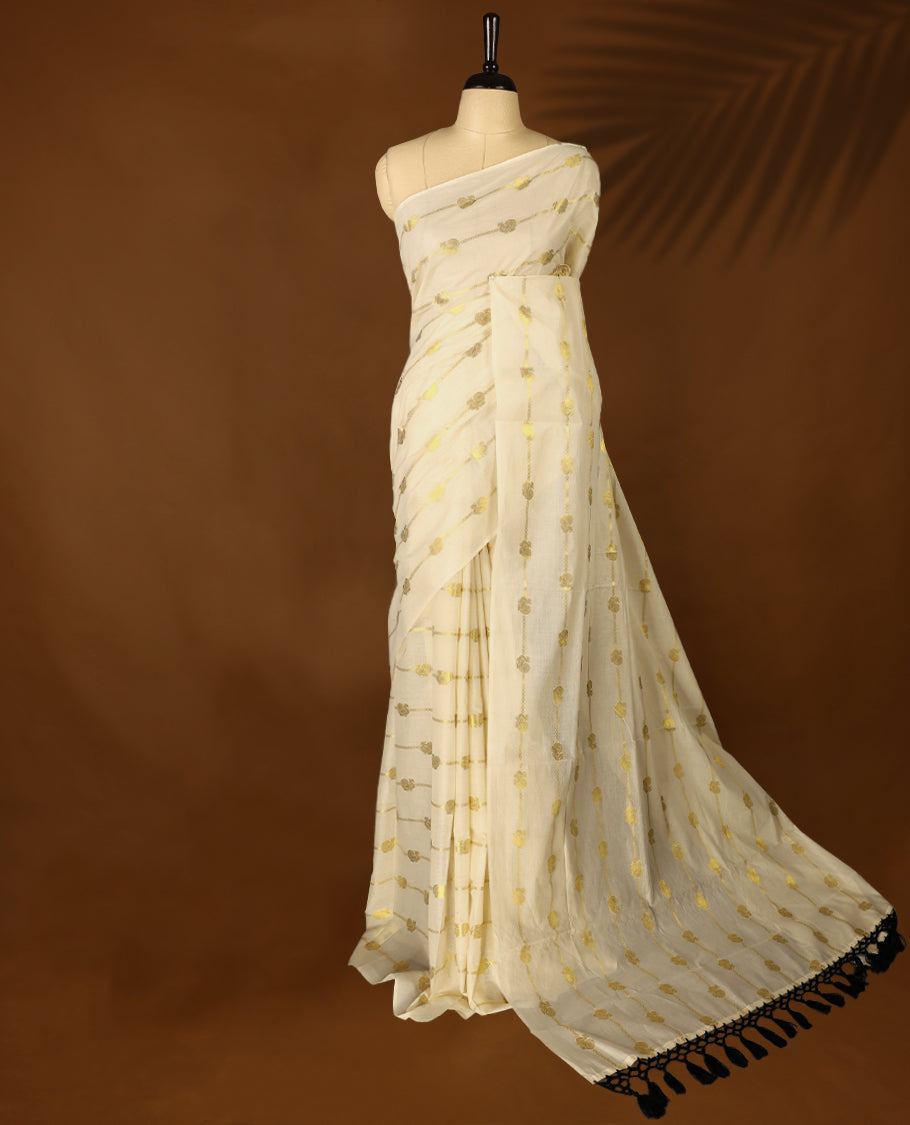 Light Gold colour Tissue Kerala saree featuring Gold zari Stripes with Peacock motifs on body, with Black colour tassels with a matching blouse perfect for festive occasions.
