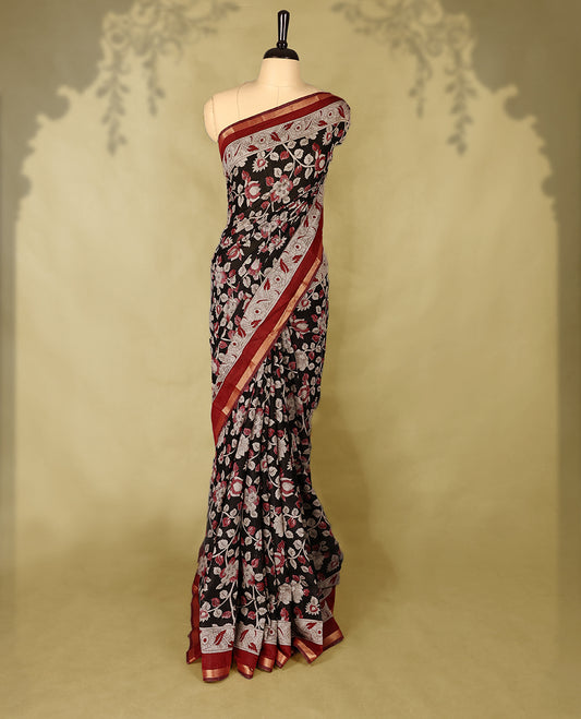 Black colour chanderi cotton saree with floral printed body, maroon border with traditional floral motifs, intricately designed pallu with peacock and floral patterns, with matching blouse